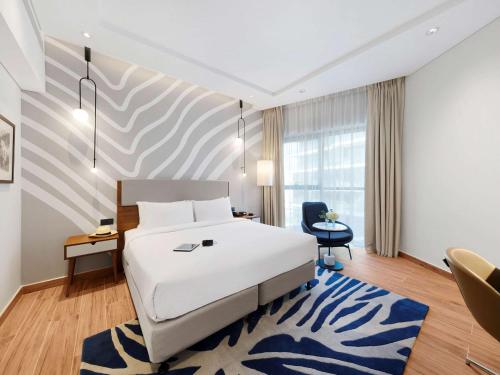 迪拜Adagio Premium The Palm的酒店客房,配有床和蓝色地毯