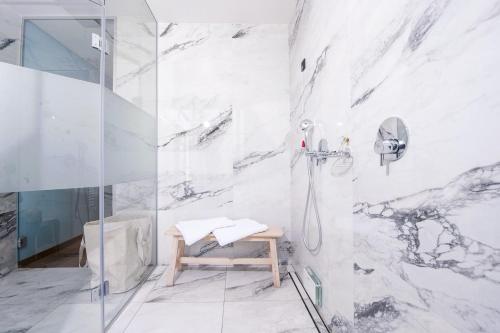 多布尔纳Spa Suite Dobrna - Terme Dobrna的带淋浴的浴室和长凳