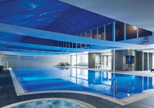 绍斯波特福姆比厅高尔夫度假酒店及水疗中心的一座拥有蓝色天花板的大型游泳池
