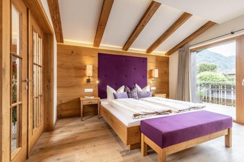 阿尔普巴赫谷地赖特Das JUWEL Reith的一间卧室配有一张大床和一个紫色床头板