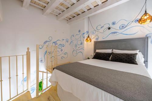 塔里法钟爱之家酒店的一间卧室配有一张床和壁画墙