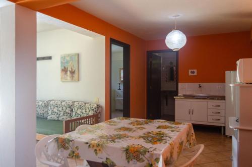 伊利亚贝拉Casa Ilhabela - melhor custo benefício的一间带桌子的房间和一个带沙发的厨房