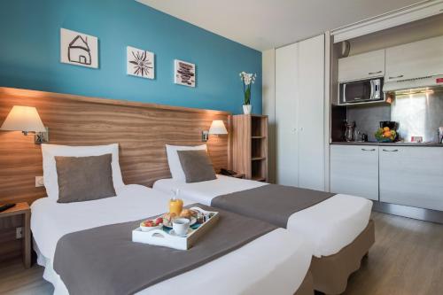 瓦讷瓦纳舒适城市公寓酒店的一间酒店客房,配有两张床和一盘食物