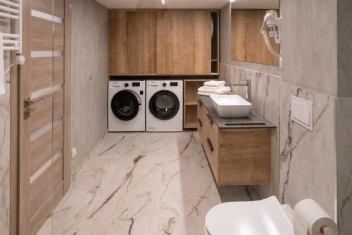 马热伊基艾NOMAD APARTMENTS的浴室配有洗衣机、洗衣机和烘干机。