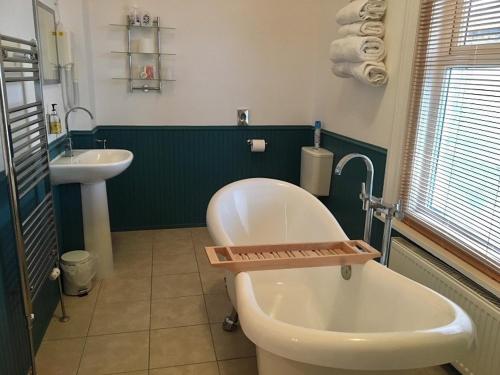 桑当杰斯盾庄园酒店的浴室配有白色浴缸和水槽