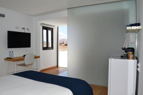 拉桑塔Habitación con baño y entrada independiente的卧室配有白色的床和冰箱。