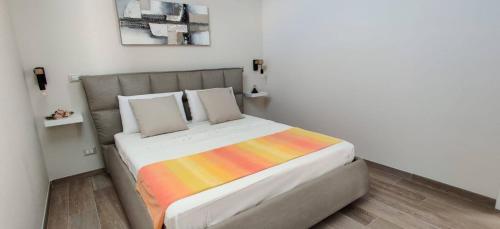莫诺波利Le casette的一间卧室配有一张带彩色毯子的床