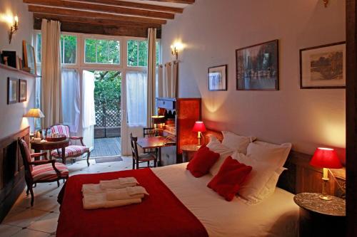 昂热马蒂尔德尚布尔酒店的一间卧室配有一张带红色枕头的大床