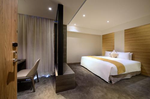 花莲市成旅晶赞饭店-花莲假期的酒店客房配有一张床、一张桌子和一把椅子。