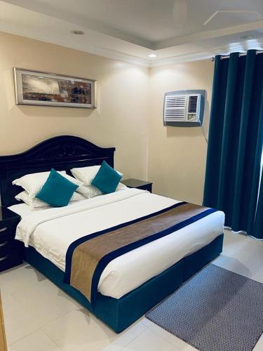 泰布克بنان للشقق المفروشة的一间卧室配有一张带蓝色枕头的大床