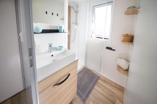 莱马特Mobile home 3 chambres 2 salles de bains dans camping 4 étoiles aux charmettes MH k168的白色的浴室设有水槽和淋浴。