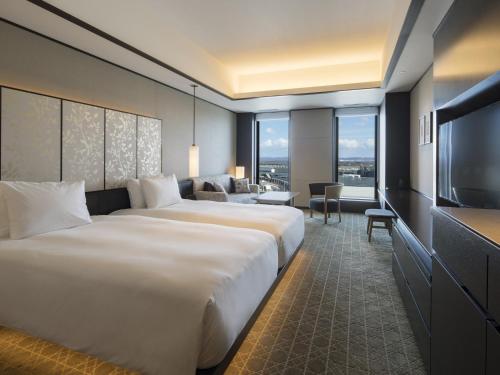 千岁Portom International Hokkaido的酒店客房设有两张床和一台平面电视。