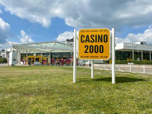 蒙多夫莱班Casino 2000 - Adult Guests Only的坐在建筑物前面的草上的一个黄色标志