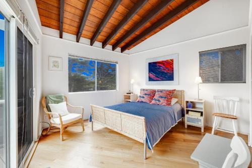博德加湾Pelican House的卧室配有一张床和一张桌子及椅子