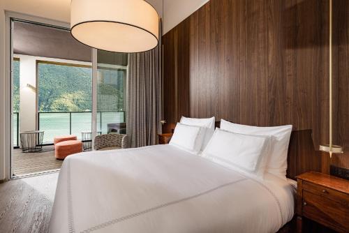 波尔莱扎ARIA Retreat & SPA - The Leading Hotels of the World, located within Parco San Marco Resort的卧室设有一张白色大床和大窗户