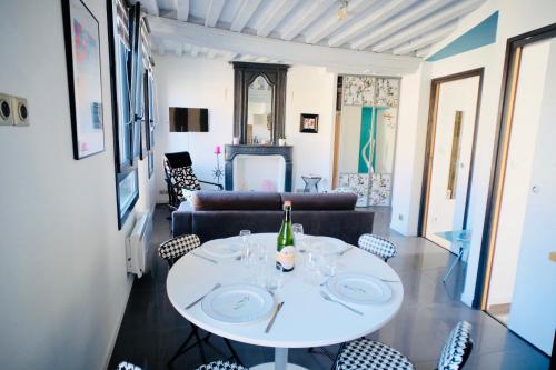 凯恩le Perroquet Fringant的客厅配有白色的桌子和椅子