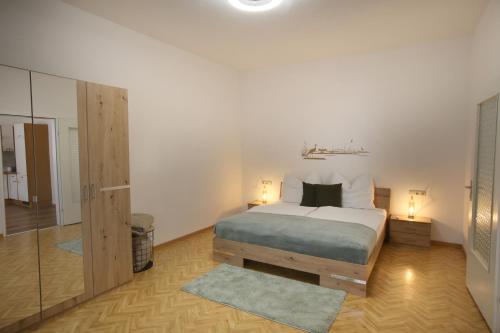 滨湖新锡德尔Appartment Weinbau Müllner的一间卧室配有一张带两盏灯和镜子的床