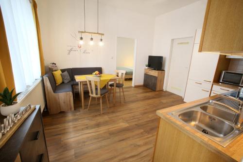 滨湖新锡德尔Appartment Weinbau Müllner的厨房以及带桌子和沙发的客厅。