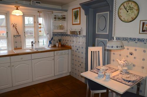 奥埃费努姆Ferien unterm Reetdach Whg 01的厨房配有水槽和带桌子的桌子。