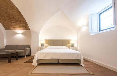 贝雅Casa do Sembrano的白色卧室配有床和沙发