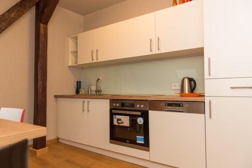 茨维考Apartmenthaus am Dom Junior Suite mit Parkplatz的厨房配有白色橱柜和烤箱。