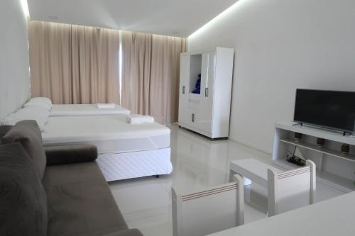 嘎林海斯港Terra Nostra Residence的白色的客厅配有床和电视。