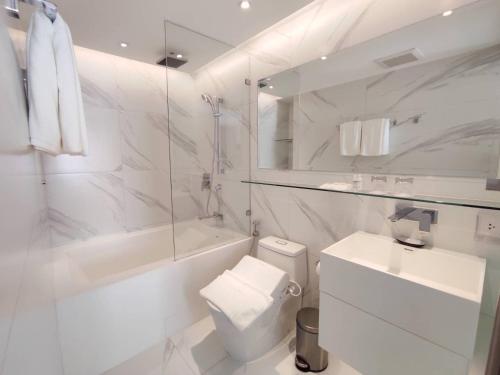 曼谷Ashley Hotel BKK的白色的浴室设有卫生间和水槽。