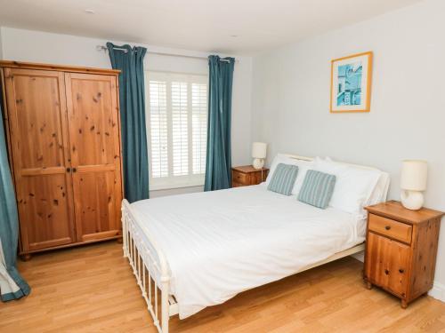 霍普湾Cindy's Retreat的卧室配有白色的床和蓝色窗帘