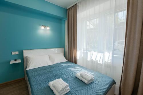 伊尔库茨克Апартаменты Небо возле Аэропорта на 2 гостя的蓝色卧室,配有带2条毛巾的床