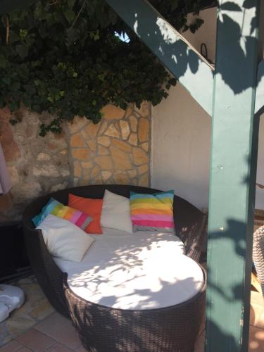保洛兹瑙克Mandula House的露台上配有带色彩缤纷枕头的藤椅