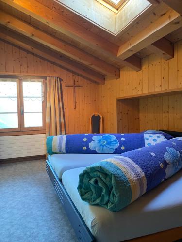 吕辰塔尔Ferienwohnung Stalden的小木屋内一间卧室,配有两张床