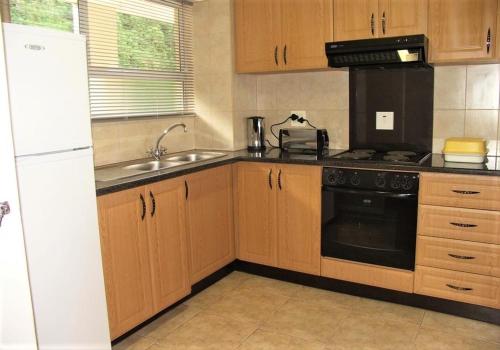 乌姆德洛蒂Cozumel 212的厨房配有木制橱柜和黑色用具