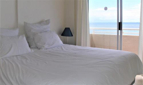 乌姆德洛蒂Cozumel 212的一张白色的床,享有海滩美景