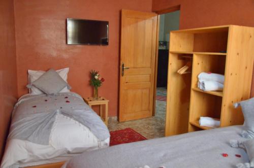 索维拉Riad Essaouira的一间卧室配有一张床,墙上配有电视