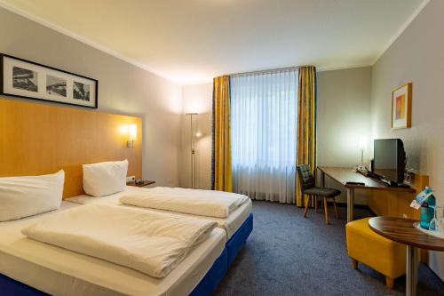 伍珀塔尔埃克索夫贝斯特韦斯特酒店的酒店客房配有两张床和一张书桌