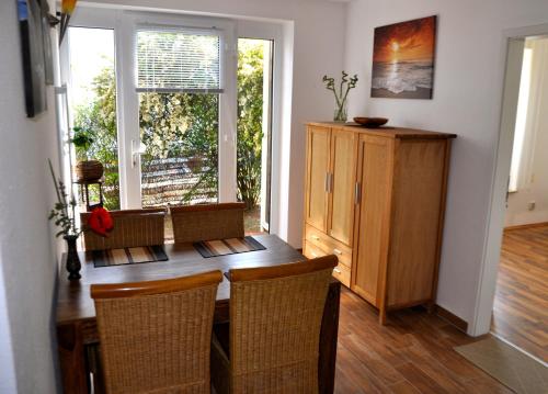 奥门豪斯特Ferienhaus Pension Sonnenblume的一间带木桌和椅子的用餐室