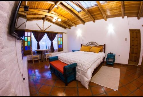 基多La Casa del colibri ecuador的卧室配有一张床和一张桌子及椅子