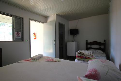 AltôniaPousada Vale do Sol的一间卧室设有一张床、一台电视和一个窗口。