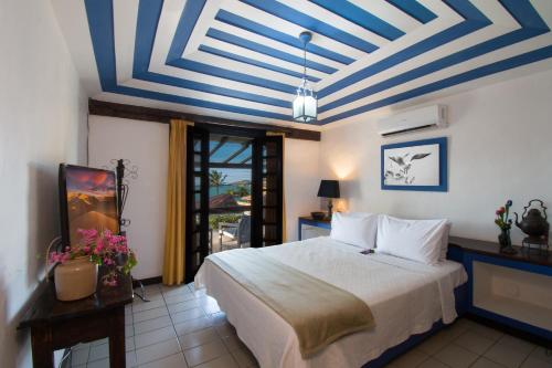 布希奥斯Pousada do Adriano的一间卧室设有一张床,拥有蓝色和白色的天花板
