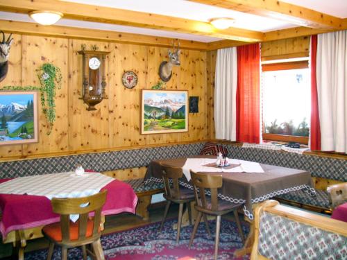 索尔登Holiday Home Willi - SOE425 by Interhome的餐厅设有2张桌子和椅子以及时钟