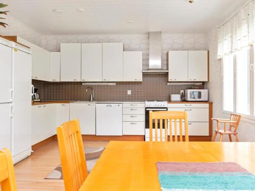 KukkolaHoliday Home Nuottiniemi 5 by Interhome的厨房配有白色橱柜和桌椅