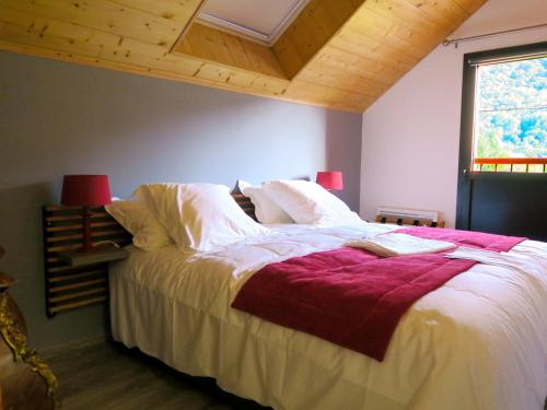ArlosL'Ôberge的一间卧室配有一张带白色床单的床和一扇窗户。