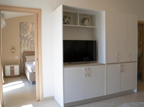 卡尔塔尼塞塔Oasi Smart Rooms的一间客厅,客厅配有白色橱柜内的电视