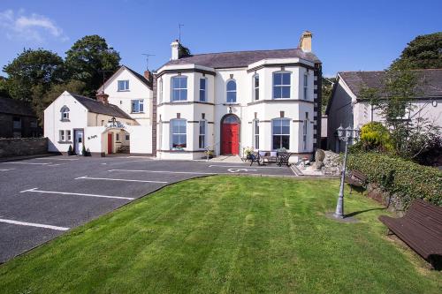 ArdglassBurford Lodge Guest House的一间设有红色门的大型白色房屋