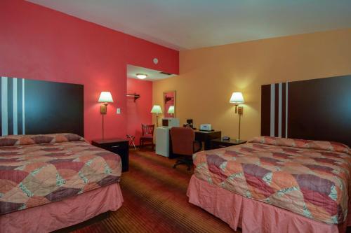 朗康科马麦克阿瑟机场罗德威旅馆的红色墙壁的酒店客房内的两张床