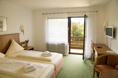 巴特塞京根aqualon Hotel Schweizerblick - Therme, Sauna & Wellness的酒店客房设有两张床、一张书桌和一个窗户。