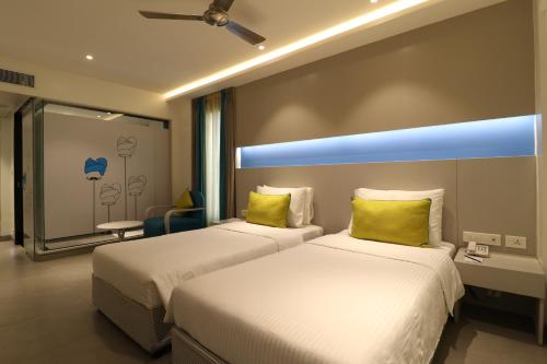 塞勒姆ZIBE Salem By GRT Hotels的配有黄色枕头的酒店客房的两张床