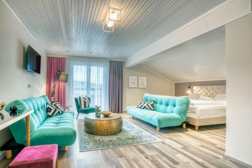 沃尔特湖畔韦尔登Hotel Eden Park的客厅配有蓝色的沙发和床。