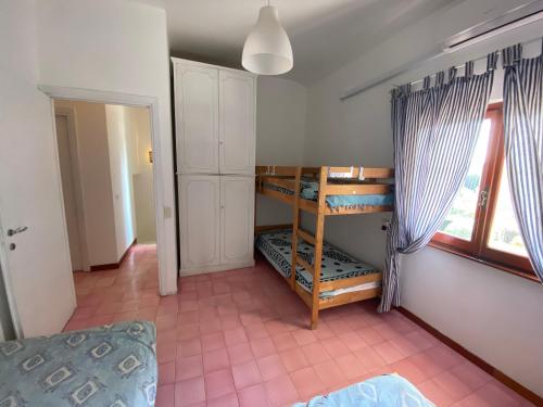 托瓦尼亚维拉吉奥拓纳兹海滩别墅的一间带双层床的卧室,位于带窗户的房间内
