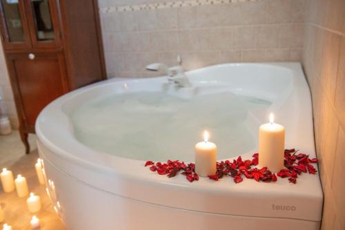 普蒂尼亚诺Tenuta Ulivi的浴缸配有两根蜡烛和红色鲜花